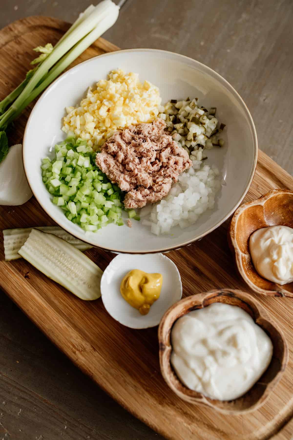 ingredients prepped to make tuna salad: tuna mustard yogurt mayo onion eggs pickles celery.