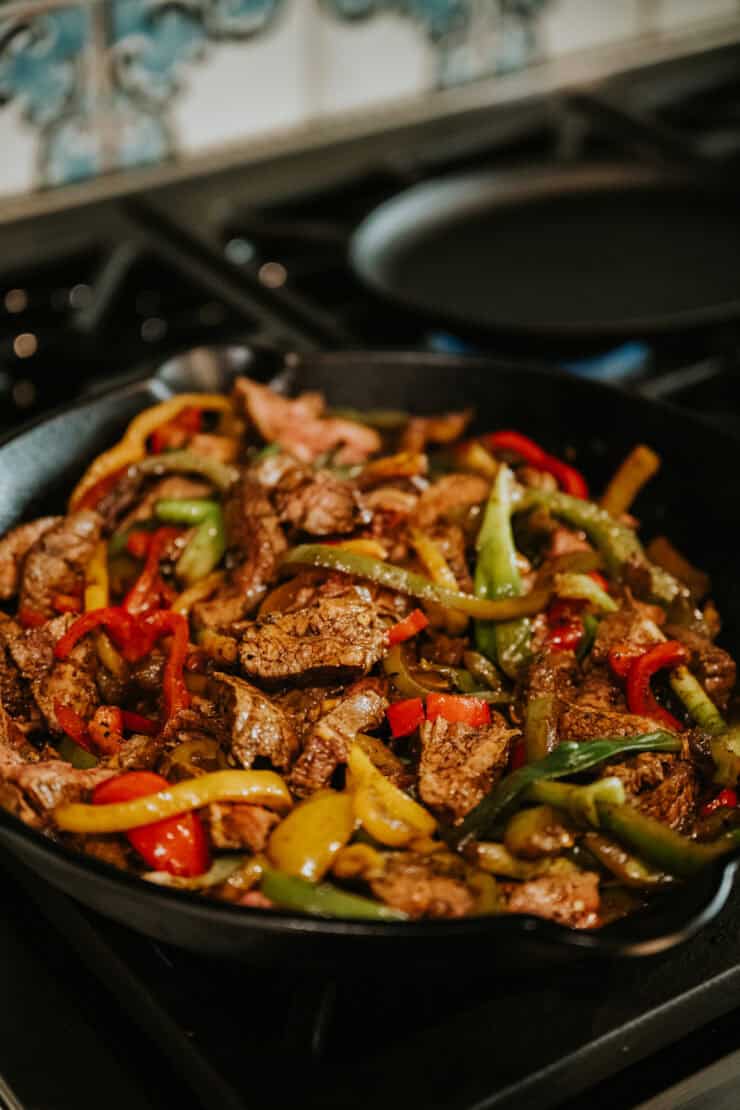 steak fajita skillet mixture after adding the steak slices back to the skillet with the cooked onions and peppers; the meat is fully cooked through. 