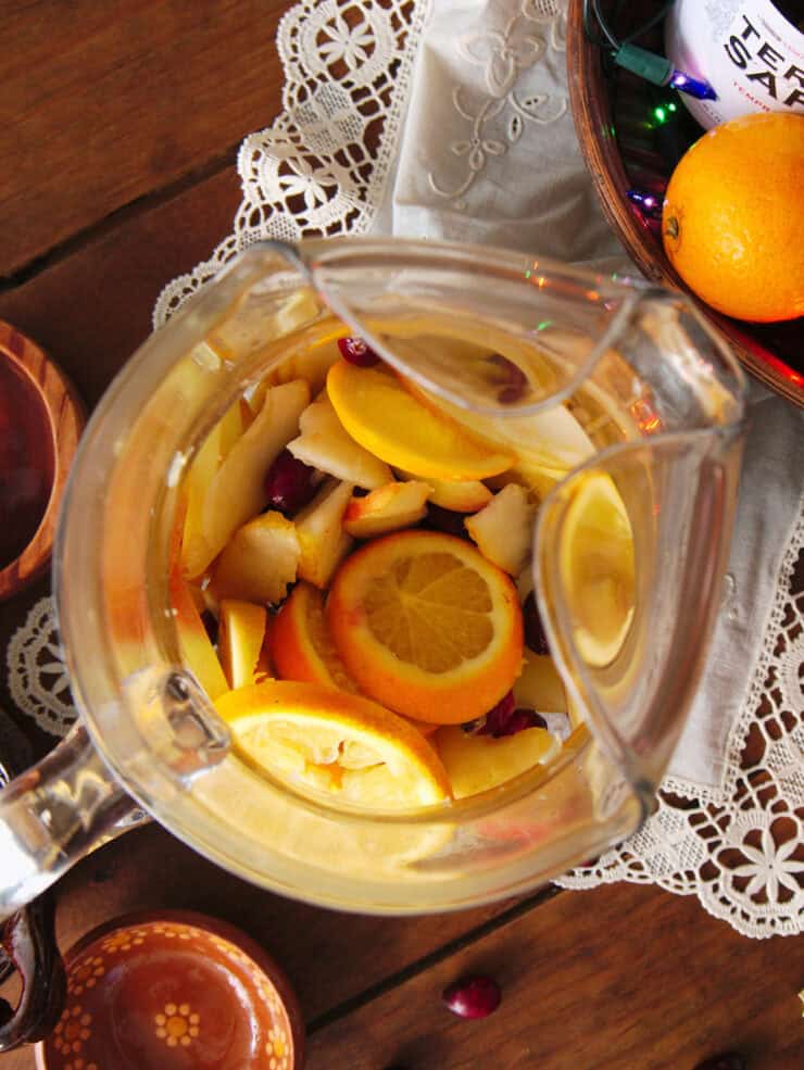 overhead shot looking down into the pitcher with fully muddled fruit for making Christmas sangria. 