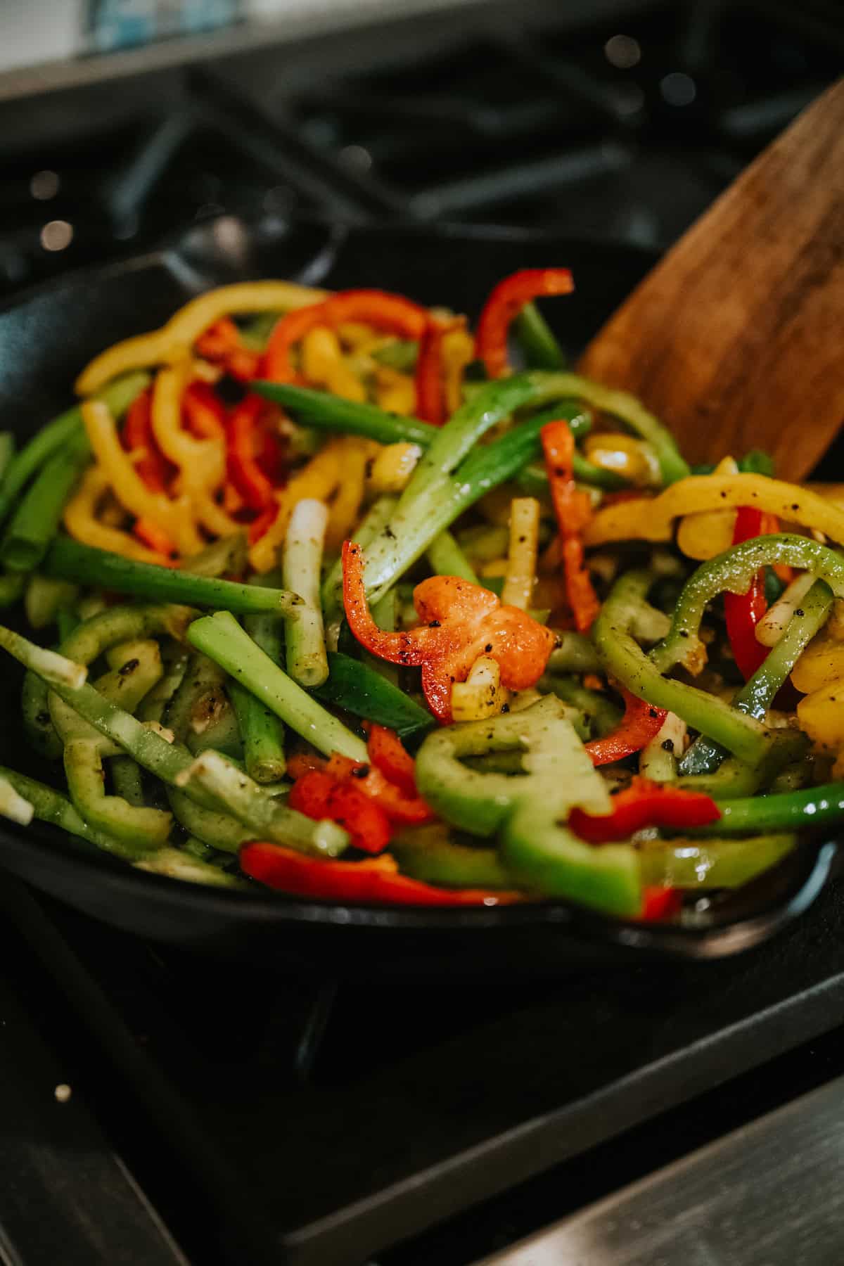 tri-color pepper slices and quartered green onions added to the now-empty cast iron skillet. 