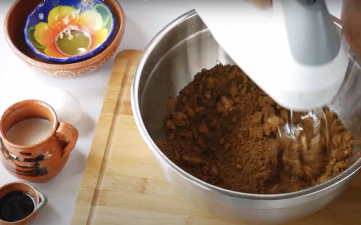 action shot of creaming butter and grated piloncillo in a stand mixer. 