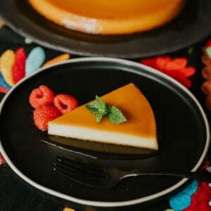 Whole baked Puerto Rican flan on a serving plate topped with glossy caramel.