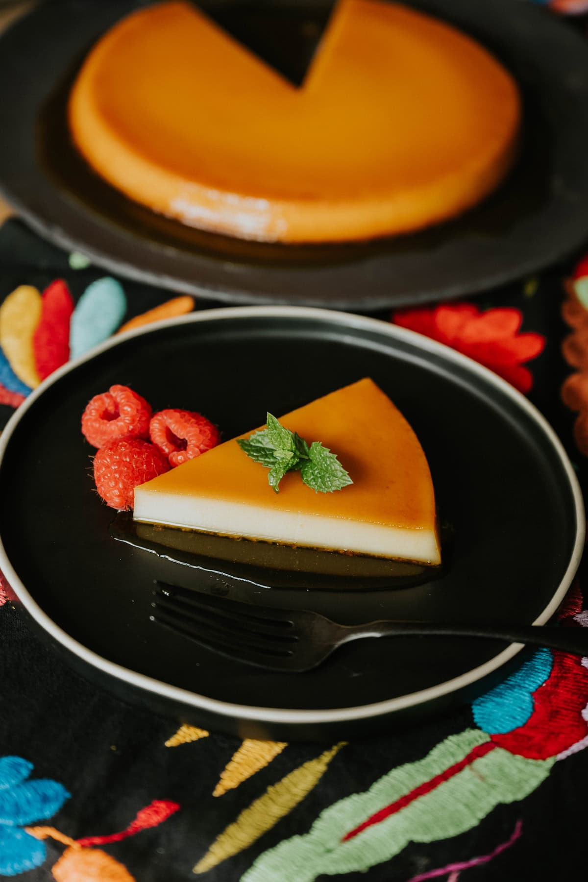 Whole baked Puerto Rican flan on a serving plate topped with glossy caramel.