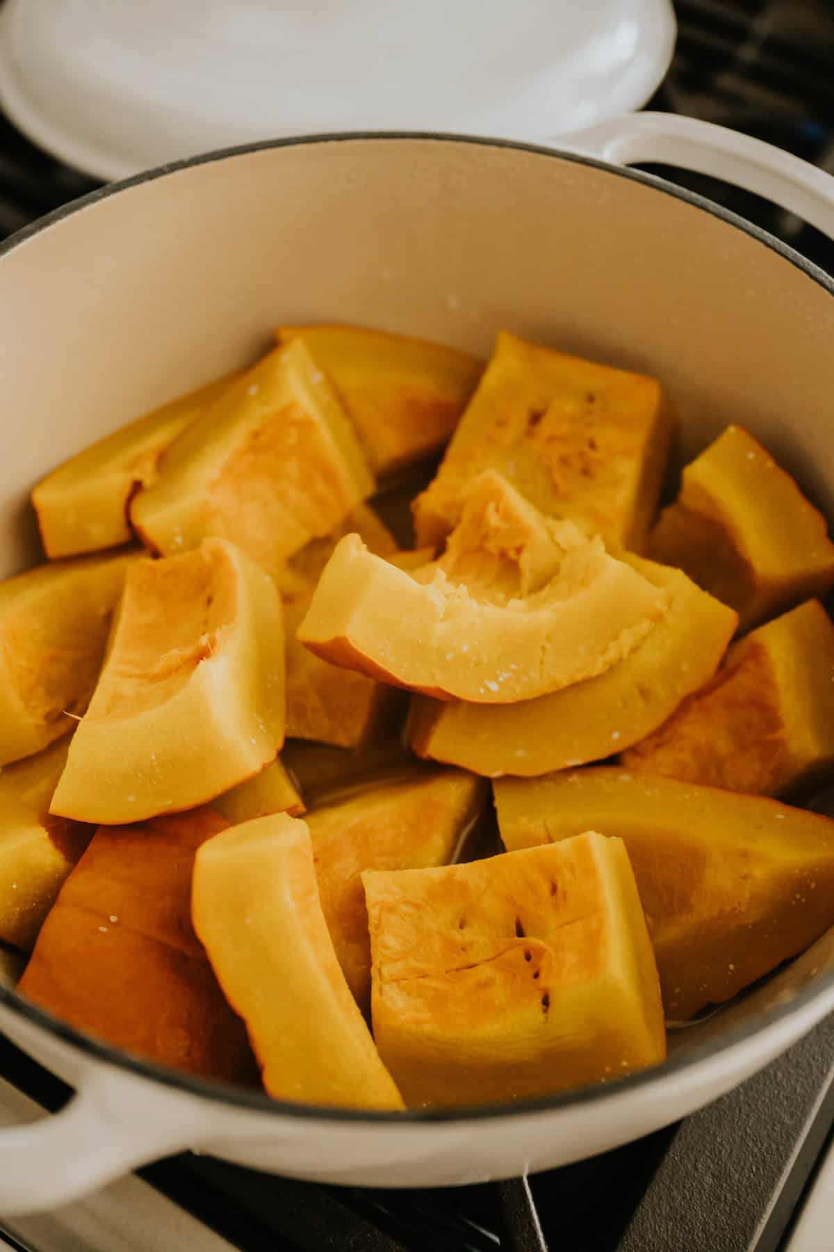 Fresh pumpkin pieces steaming in a pot.