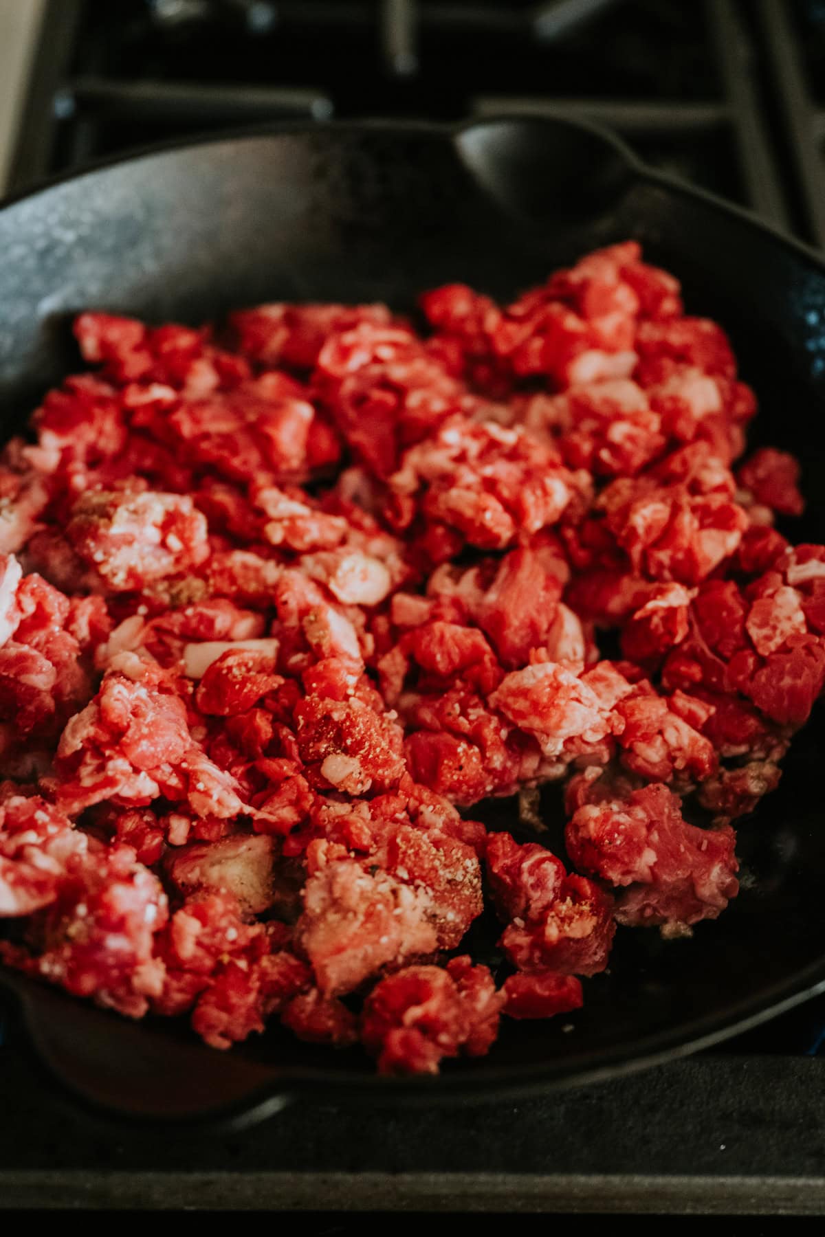 Seasoned beef taco meat cooking in a hot skillet.