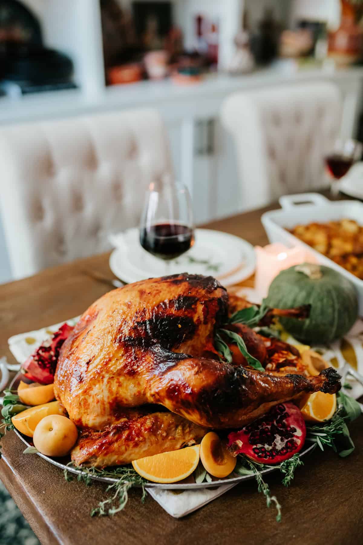 Pavo Enchilado Mexican roast turkey glazed with apricot butter and red chile sauce, garnished with oranges and fresh herbs on a Thanksgiving table.